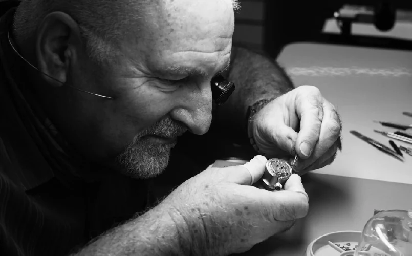 Image of watchmaker inspecting watch dial