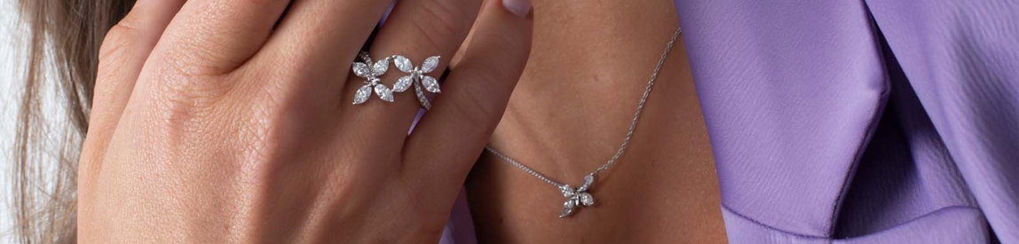 Diamond Floral Ring on Model's Finger with Matching Necklace. 