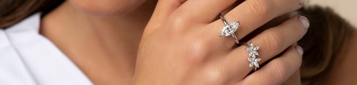 Marquise and Floral Diamond Rings on Model's Fingers. 