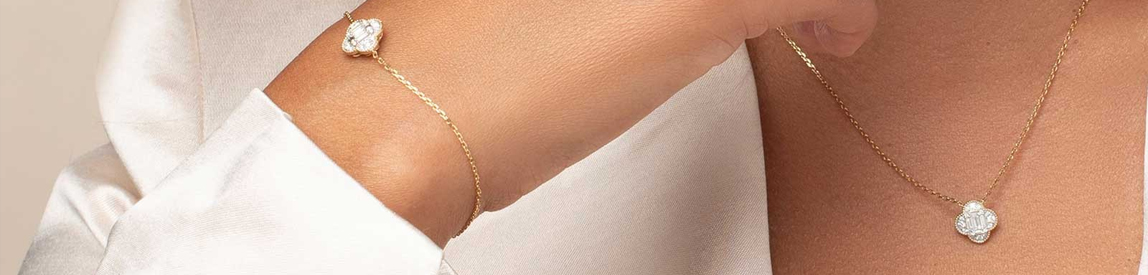 Model wearing a matching diamond necklace and bracelet set. 