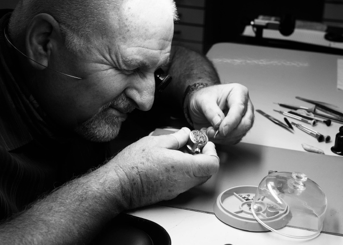 Pre-Owned Watches (Image: Watchmaker inspecting a pre-owned timepiece)