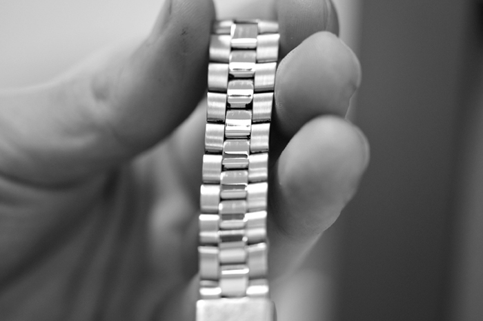 Bracelet Strap Replacement (image: hand holding watch bracelet)