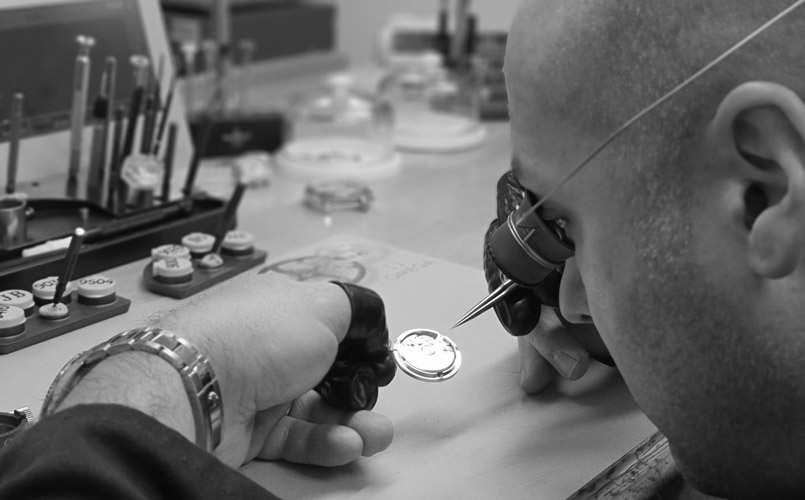 Image of watchmaker inspecting watch dial