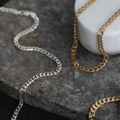 silver and gold chains on table 